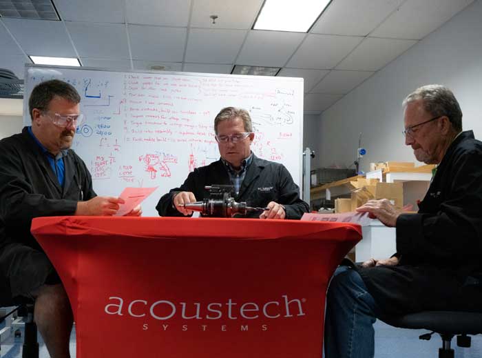 Team of Acoustech Systems Engineers reviewing product specs